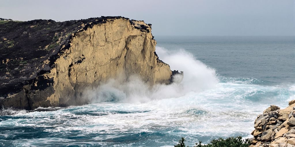 Côte française érodée par la mer, vague frappant la falaise.
